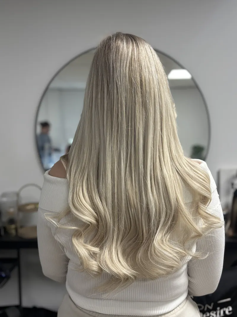 Lang, golvend blond haar met microring extensions, van achteren gezien in de studio